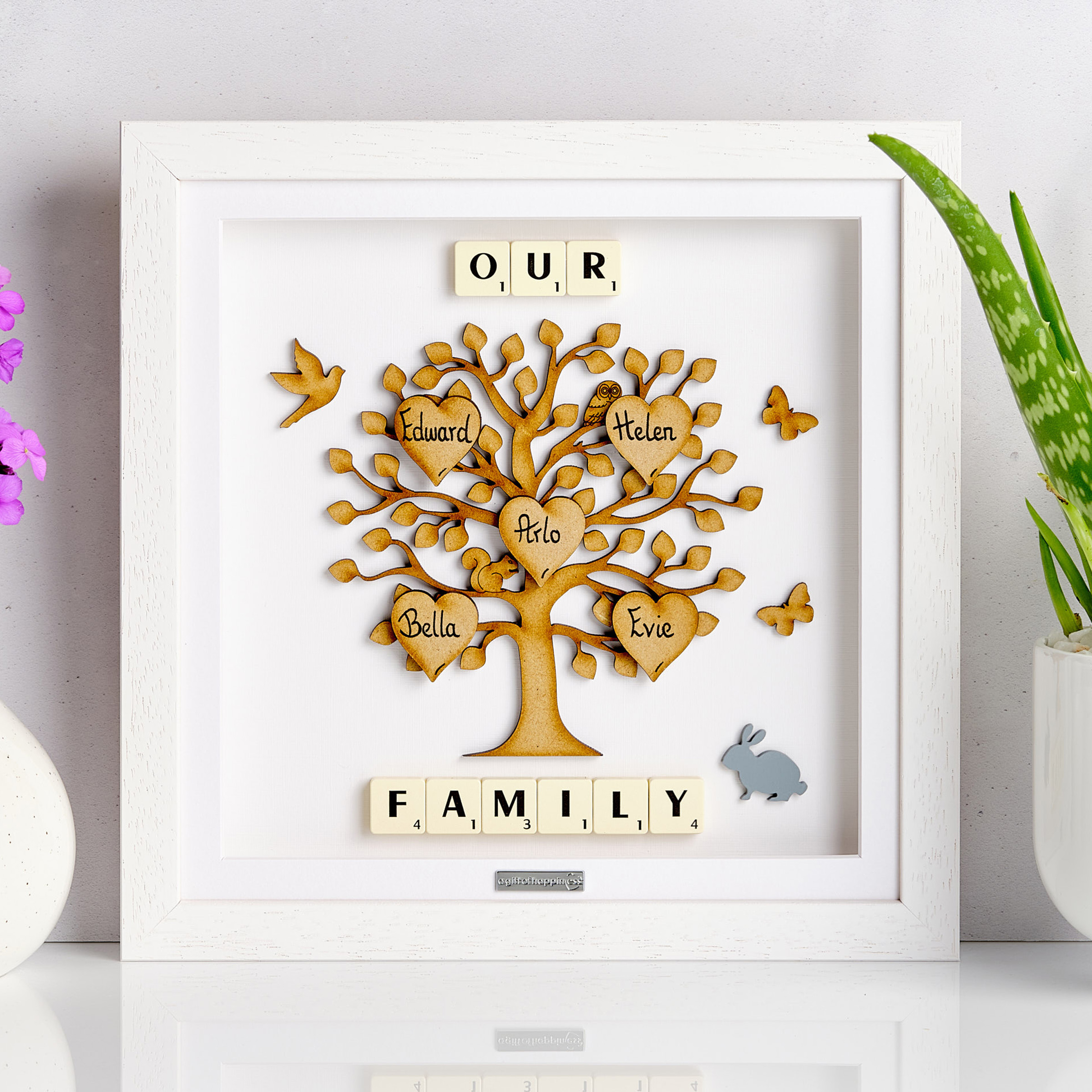 Personalised wooden family tree frame with handwritten heart names and Scrabble tiles spelling “Our Family”